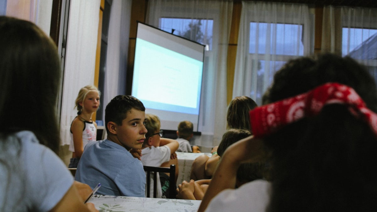 A group of kids attentively watching a classroom presentation indoors.